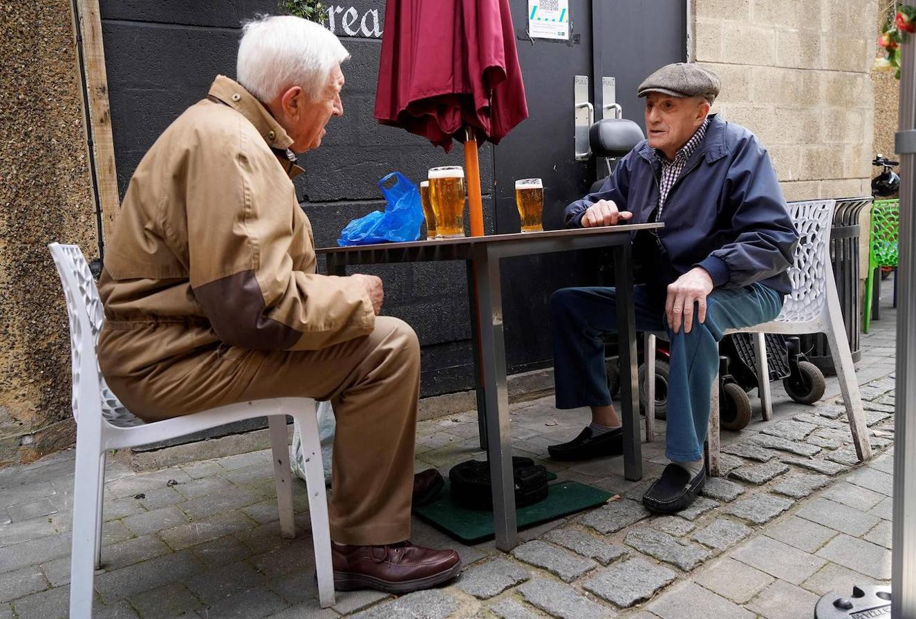 Dos hombres sin mascarilla y bebiendo cerveza en una terraza en Londres. 