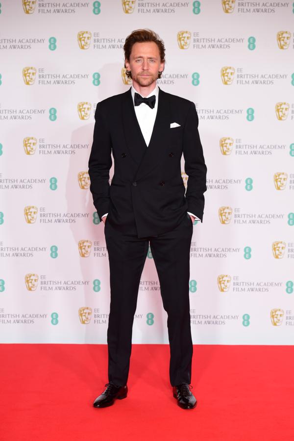 Tom Hiddleston – Los mejor vestidos de los BAFTA. Se decantó por un traje negro con las solapas cruzadas y doble abotonadura en el que además de la pajarita, no faltó un pequeño pañuelo de seda en el bolsillo izquierdo que le dotaba de u acabado todavía más sofisticado.