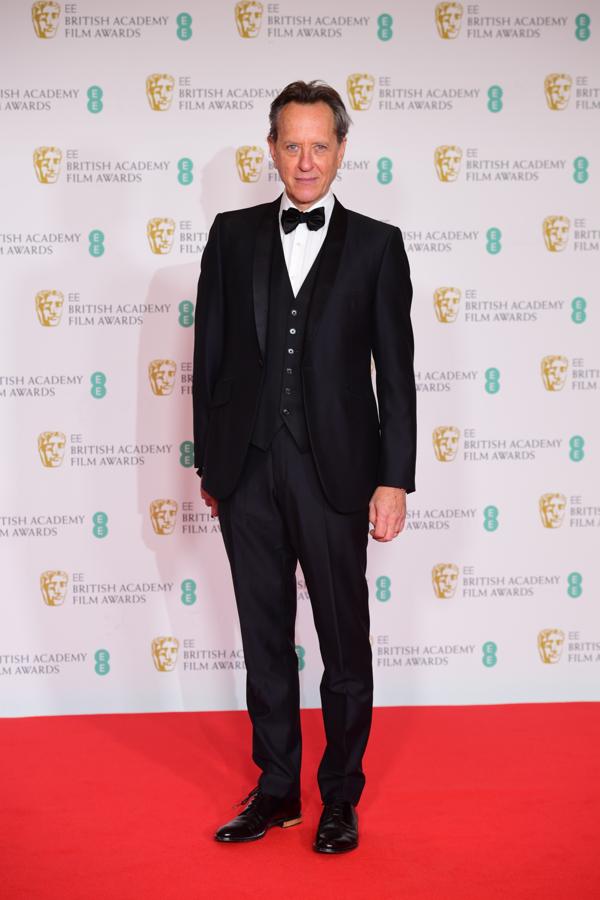 Richard E. Grant – Los mejor vestidos de los BAFTA. Muy elegante con un traje azul marino de acabado satinado que incluía un chaleco a juego y al que añadió una pajarita.