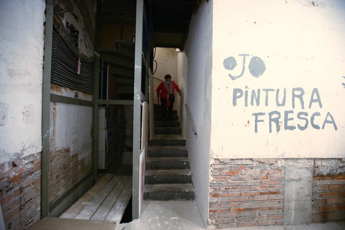 Otra mujer baja por los angostos escalones hasta la planta baja. 