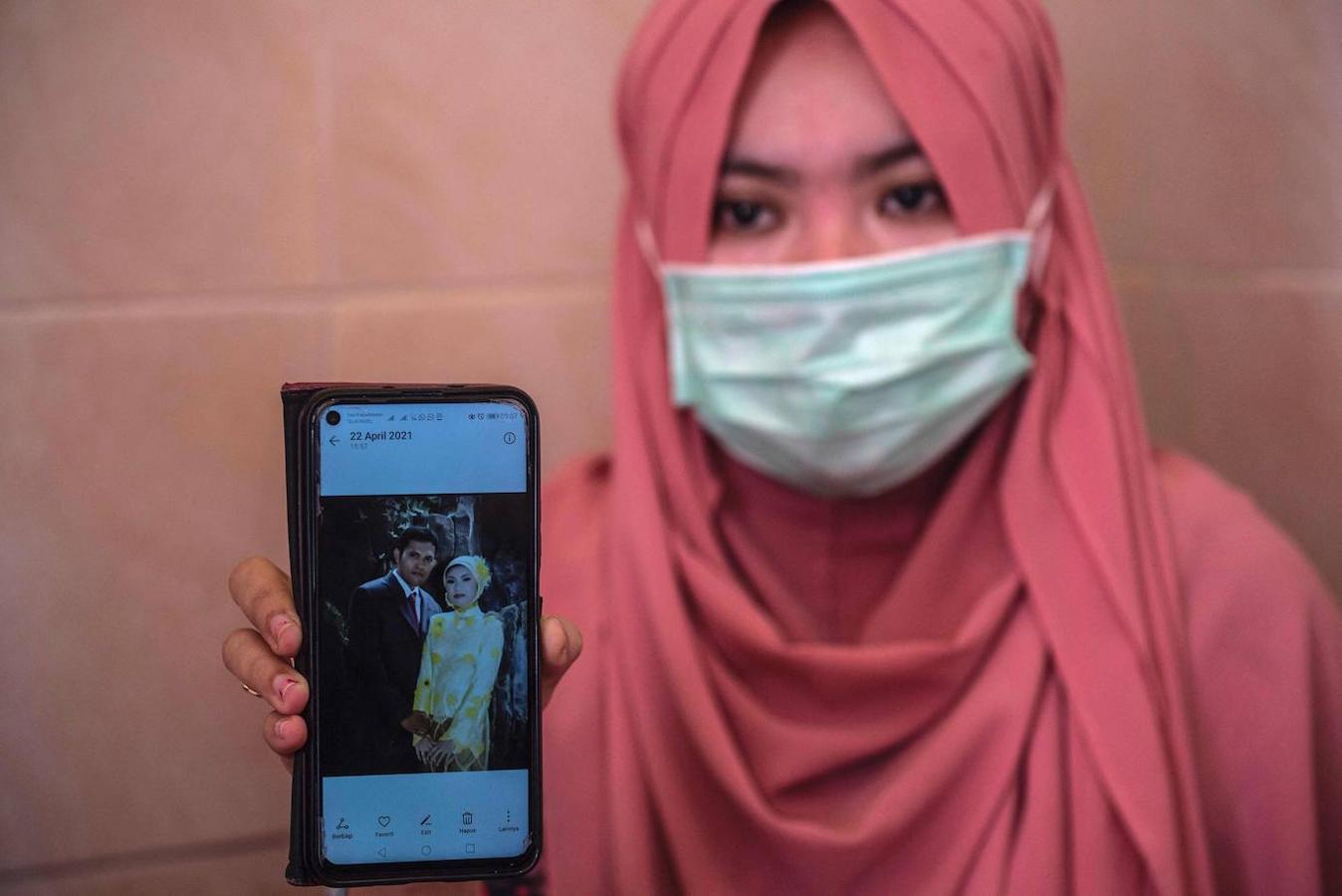 Berda Asmara muestra una foto de boda con su esposo, el marinero Mes Guntur Ari Prasetyo, en su casa en Surabaya el 23 de abril de 2021, mientras continúa la búsqueda del submarino desaparecido. 