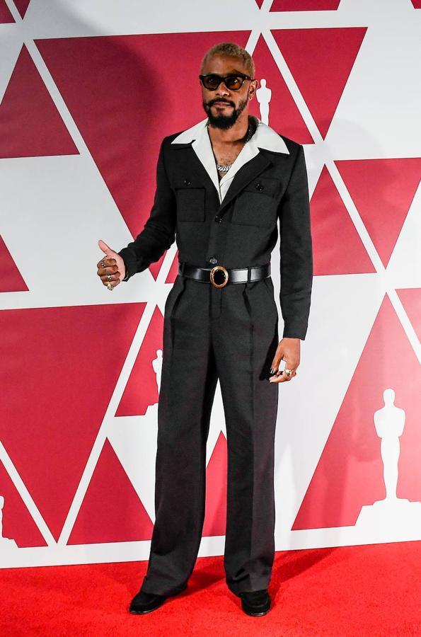 Lakeith Stanfield - La alfombra roja de los Oscar 2021. Su estilismo traslada de lleno a los años setenta gracias a un mono de Saint Laurent con el cuello XXL que dejaba entrever la camisa, tan de moda en aquella década. Remató su elección con un cinturón de piel con la hebilla dorada con el que además definía más la forma de la prenda.