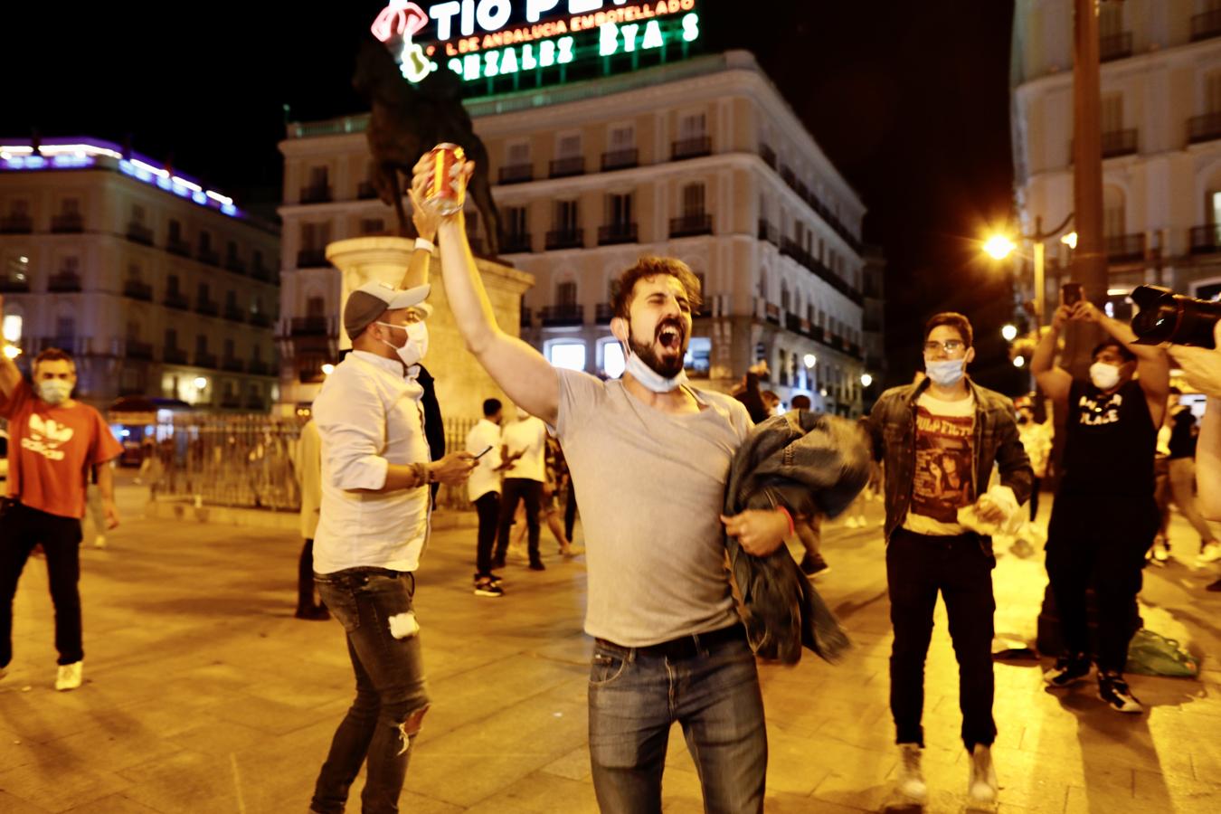 Varias personas celebran en la Puerta del Sol el fin del estado de alarma. 