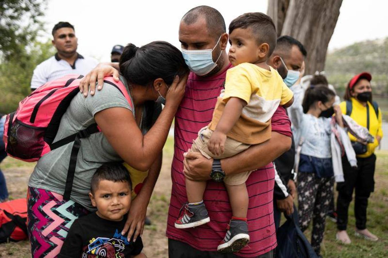 Una familia de inmigrantes espera a ser trasladada a una instalación de procesamiento de la patrulla fronteriza de EE. UU.. 