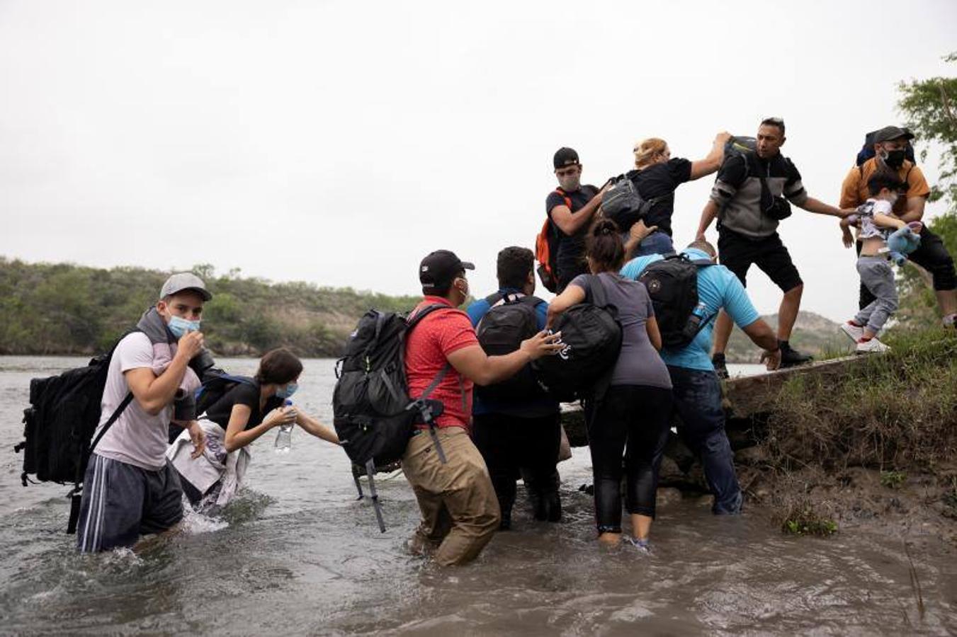 Un grupo de venezolanos se ayuda para alcanzar la orilla de EE.UU.. 