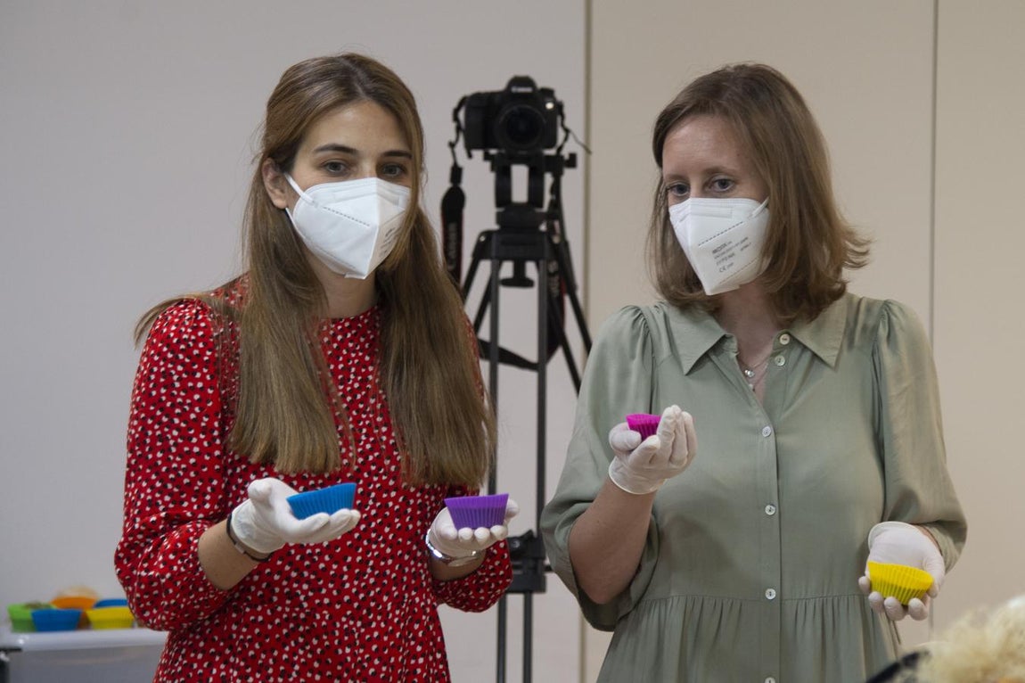 ¡Al horno!. Dos participantes en el #tallerdebienestar de batch cooking llevan al horno los moldes que contienen la mezcla del banana bread.