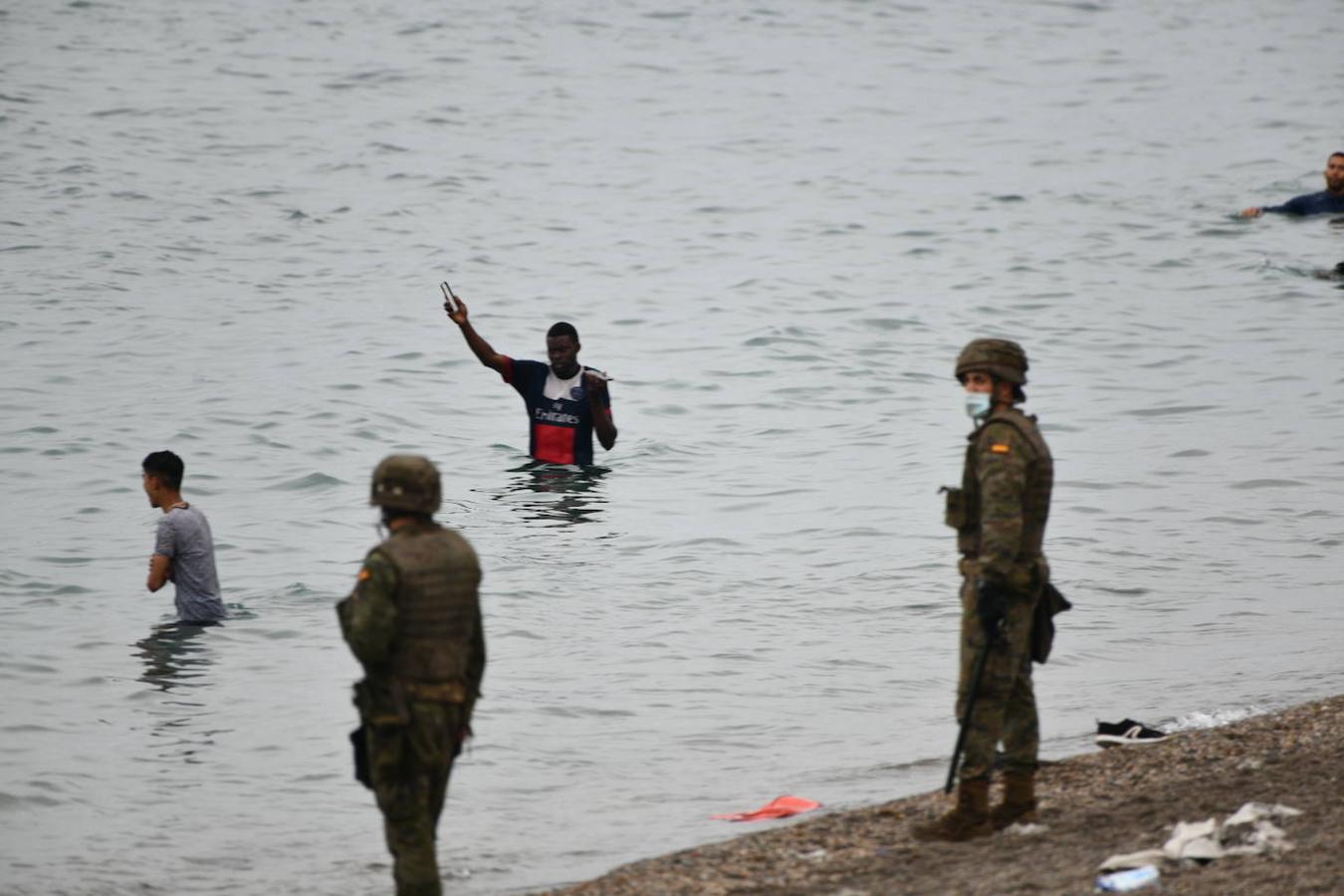 Militares españoles vigilan a los inmigrantes que han llegado a nado a Ceuta. 