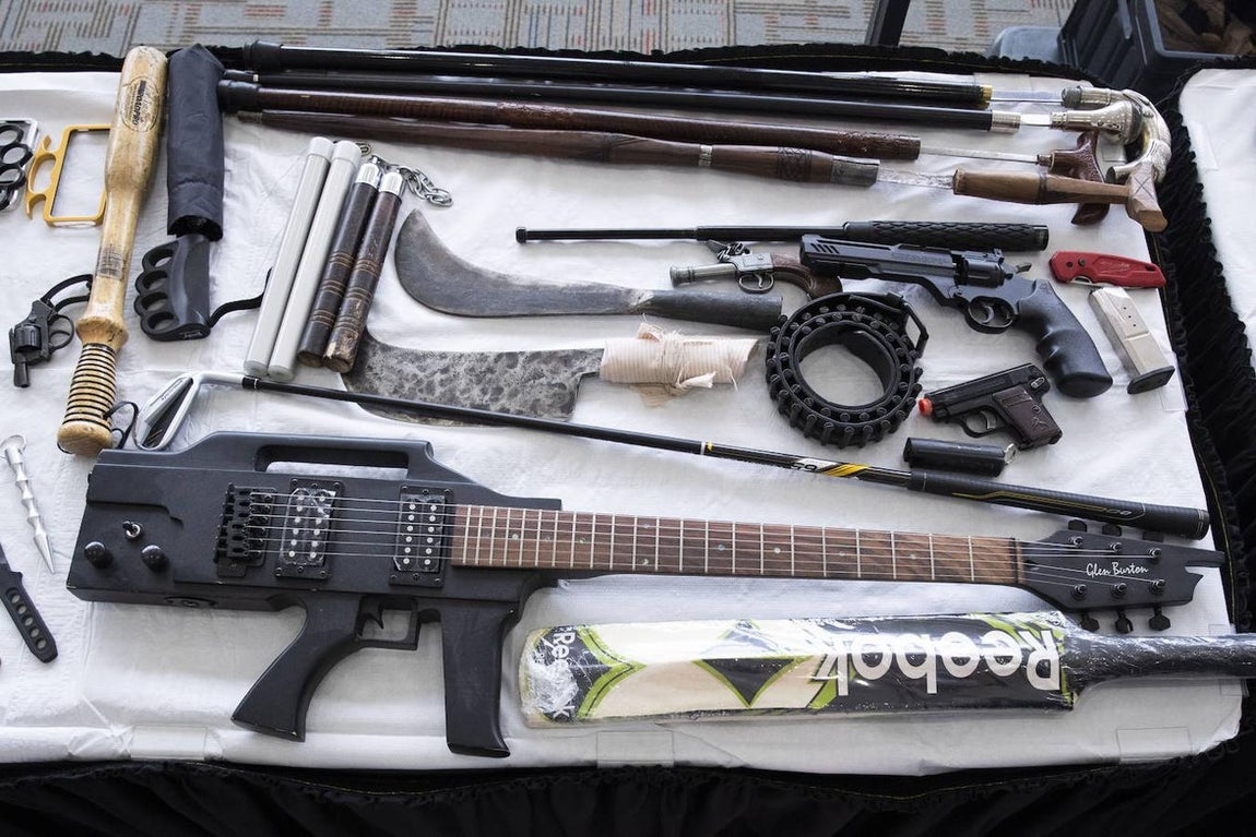 Un fusil con forma de guitarra, junto a varias armas requisadas por el TSA. 