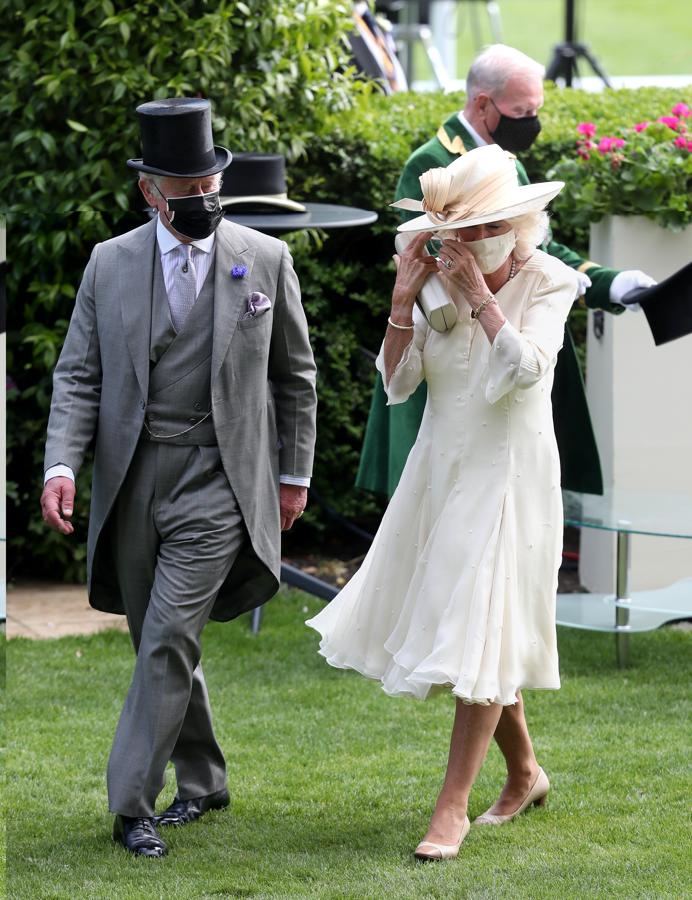 El príncipe Carlos y Camila de Cornualles - Los tocados más llamativos de Ascot 2021. En la segunda jornada Camila se ha decantado por un diseño en color beige con un lazo de gasa champán más discreto de lo que suele llevar habitualmente.
