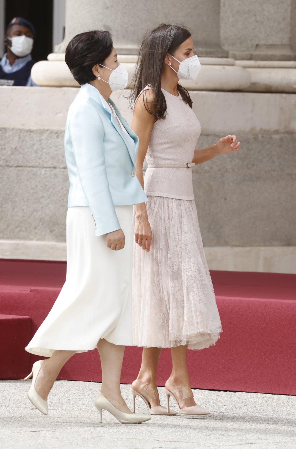 La Reina había estrenado este precioso vestido en el <a href="https://www.abc.es/estilo/gente/abci-acertado-estilo-familia-real-201810122042_noticia.html">Día de la Hispanidad de 2018</a>, entonces con una chaqueta. Esta semana para el acto en el Palacio Real se lo puso sin abrigo, debido a las altas temperaturas en Madrid, con sus salones de Steve Madden. Llevó además el pelo suelto (el viento le jugó alguna mala pasada con el peinado) y pendientes de flores de Yanes. La primera dama coreana eligió por su parte un vestido blanco roto con americana corta en azul claro y un soberbio collar de perlas.