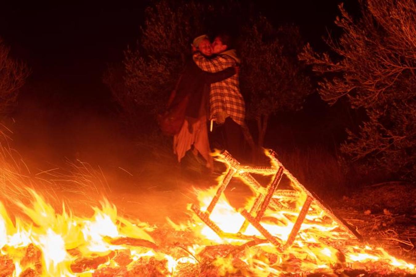 Dos mujeres se abrazan junto a una hoguera para celebrar la noche de San Juan en las inmediaciones de la localidad de Lajares, en La Oliva (Fuerteventura). 