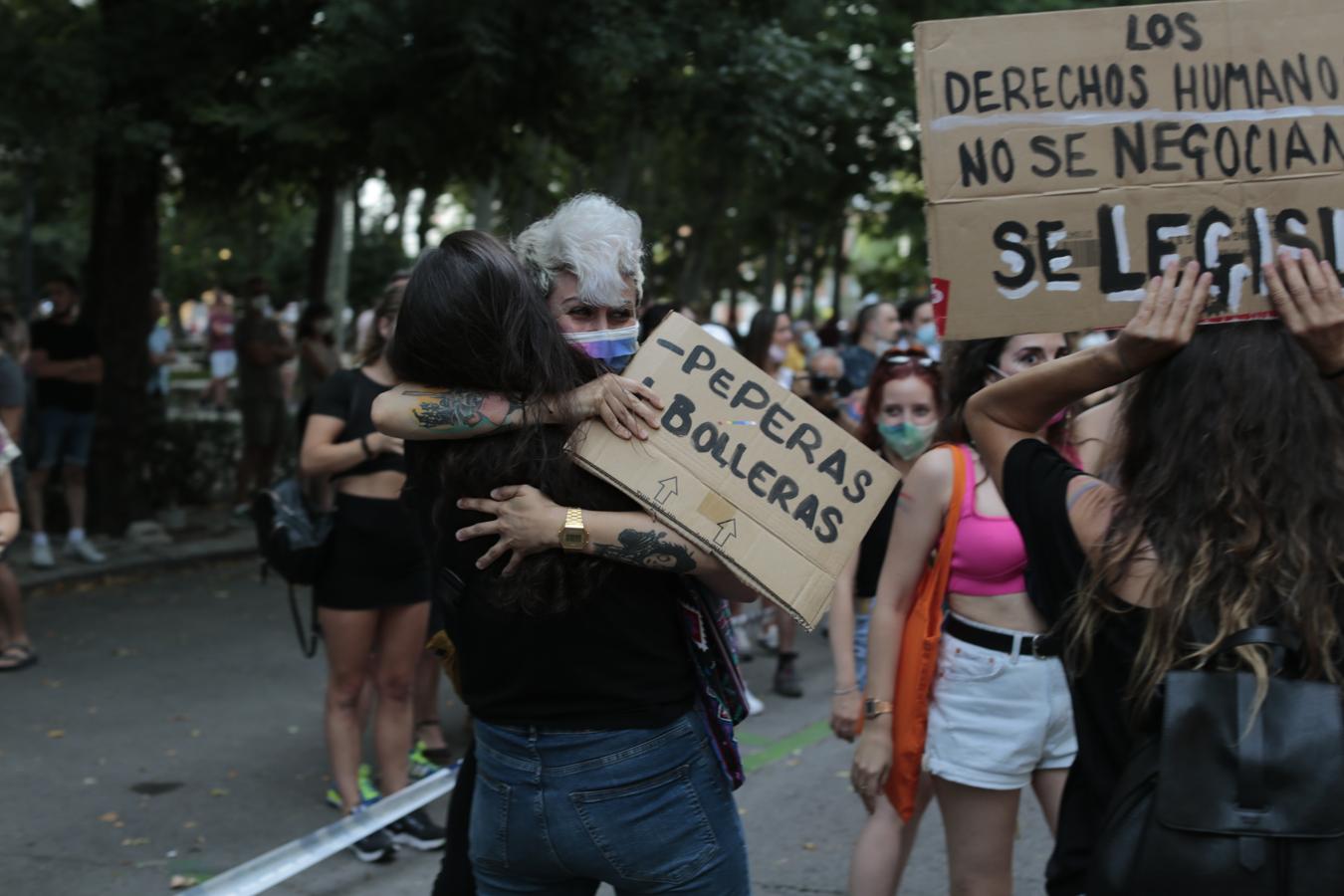 Dos mujeres se abrazan con un cartel en el que se puede leer «- peperas, + bolleras». 