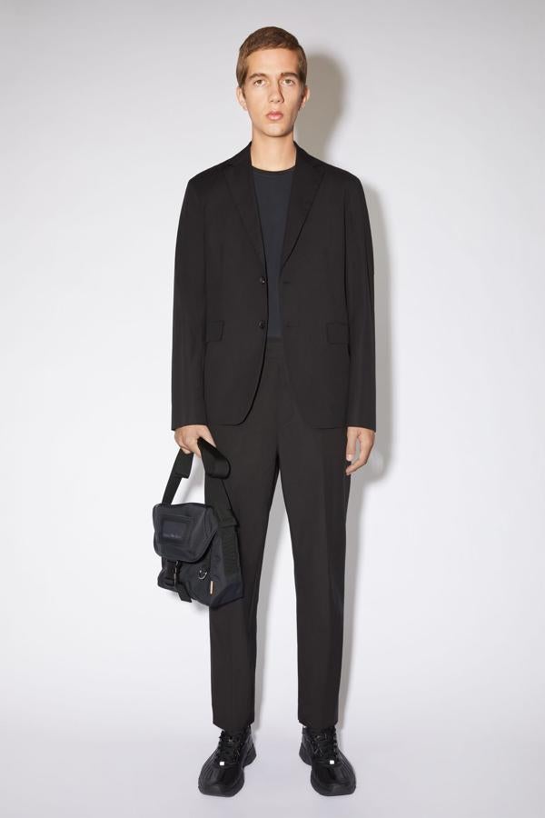 Traje negro de Acne Studios. Por último, un recurso para los que no renuncian al traje negro en ninguna circunstancia. Este de Acne Studio es completamente liso y no tiene detalles diferenciales pero sí que promete un gran ajuste y un corte a la última para que puedas lucirlo a lo grande en cualquier ocasión. Precio: 780 euros.