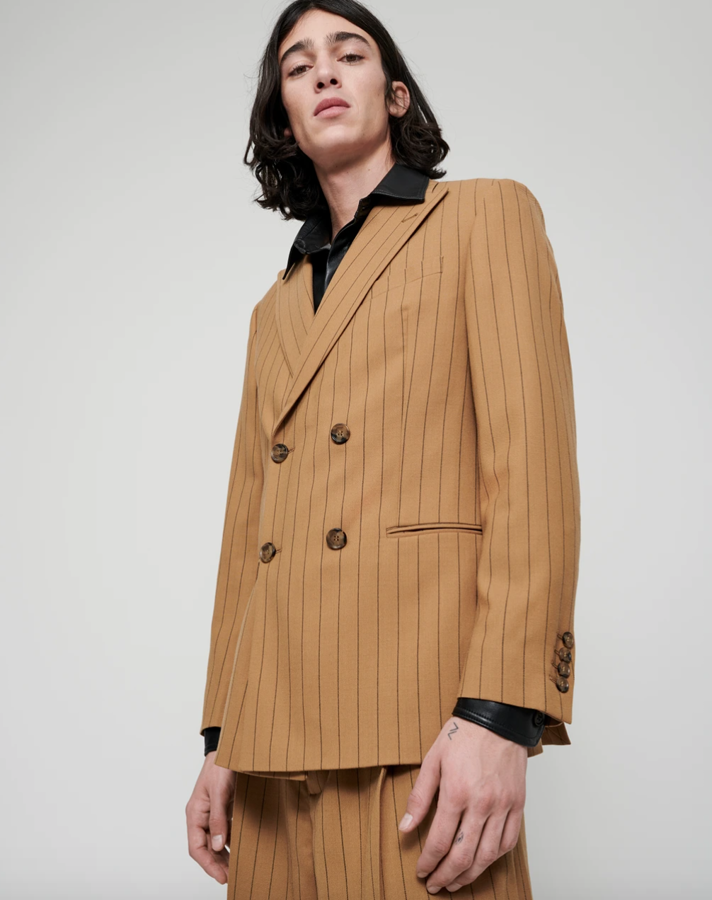 Traje a rayas de Nanushka. De la colección Resort 2021 de Nanushka nos quedamos con esta blazer a rayas negras y camel bautizada como Malvin que está fabricada con tejido parcialmente reciclado conservando una sensación de refinada facilidad y elegancia, está cortado para una cómoda silueta cruzada y forrado en satén. Precio: 606 euros