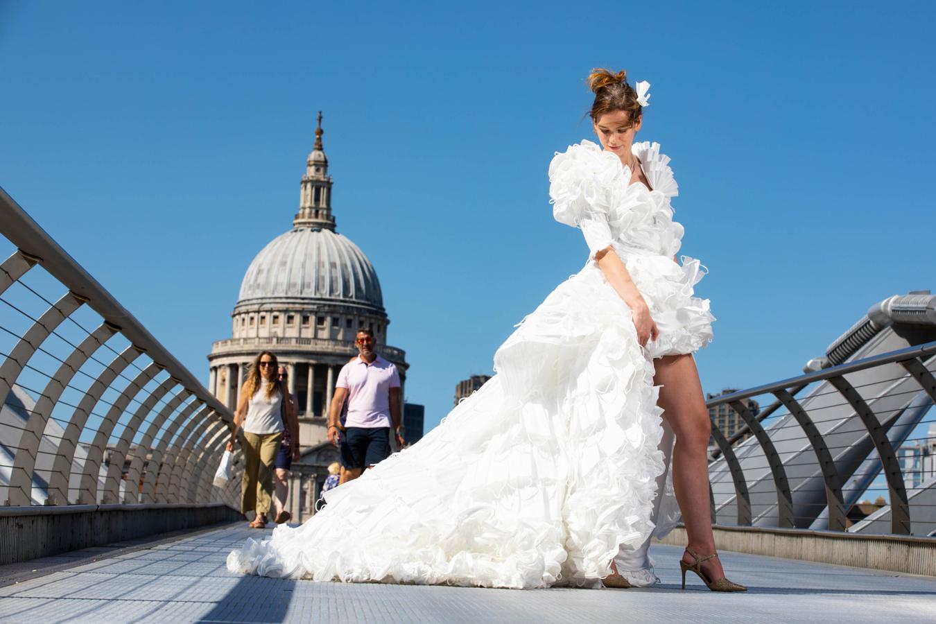 Jemima Hambro modela un vestido de novia diseñado por Tom Silverwood hecho con más de 1.500 mascarillas en Millennium Bridge. 