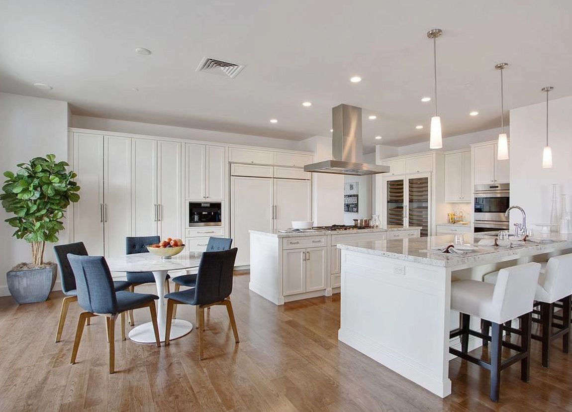 Así es el penthouse de Matthew Perry. La cocina del chef dispone de gabinetes en blanco, electrodomésticos de alta gama, una nevera para vinos y dos islas con encimeras de mármol que ofrecen una barra de desayuno, fregadero y los fuegos. Incluye, también, una pequeña zona de comedor.