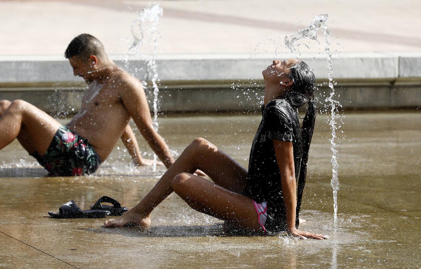 Dos turistas se refrescan en una fuente de Córdoba durante la ola de calor. 