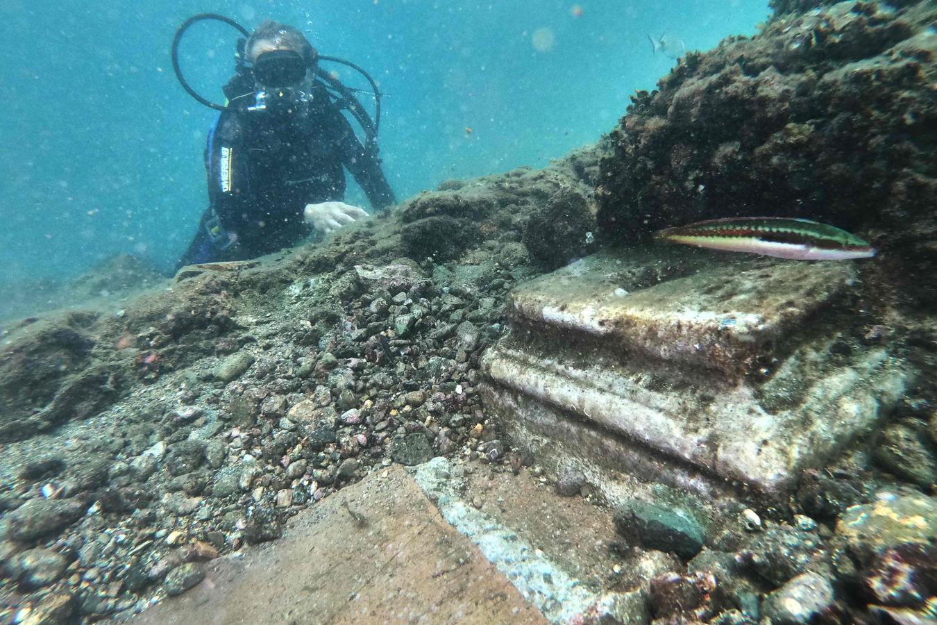 Refugio de emperadores. Esta antigua ciudad, situada en la caldera volcánica de los Campos Flégreos, el noroeste de Nápoles, fue hogar de emperadores. Alrededor del siglo IV, los pórticos, las columnas de mármol, los santuarios y los estanques ornamentales empezaron a hundirse debido al mencionado fenómeno del bradisismo. En la foto, el guía muestra un capitel sumergido.