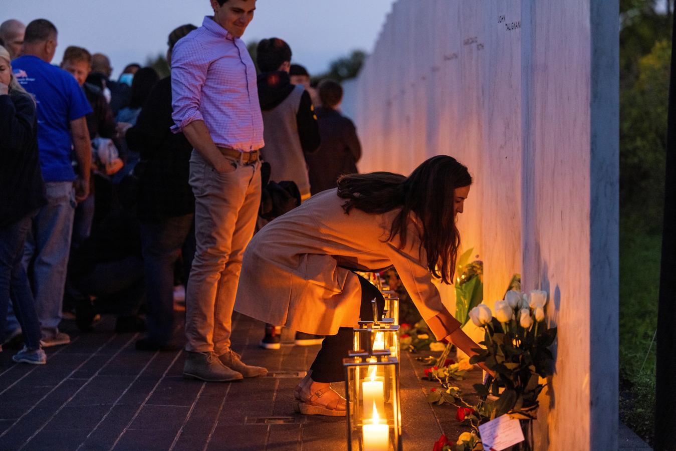 Una mujer coloca el candelabro en el piso para la vigilia a los caídos en el Vuelo 93 de United Airlines. 