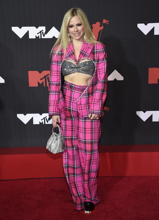 Avril Lavigne, en la alfombra roja de los MTV VMA's 2021. La cantante escogió un llamativo traje de chaqueta con estampado de cuadros en color fucsia con la parte delantera simulando un corazón.