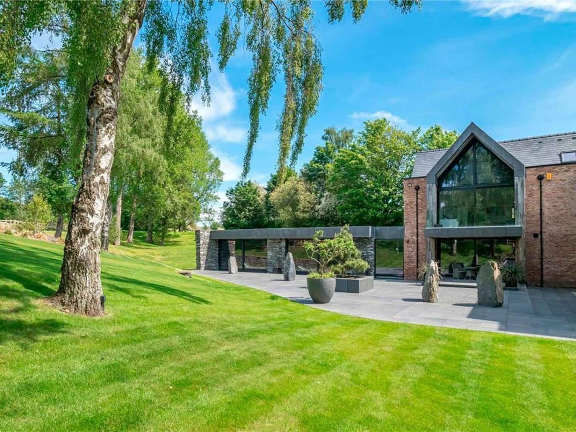 La vivienda, de arquitectura moderna y con grandes ventanales, cuenta con amplios espacios verdes para que jueguen los niños de la pareja. 