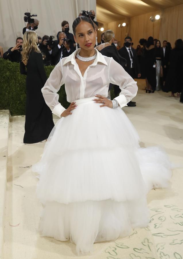 Alicia Keys - Alfombra roja de la Gala MET 2021. Como si de una bailarina se tratase, lució una voluminosa falda de tul blanco con varias capas y la combinó con una camisa semitransparente a juego. Remató su elección con pendientes y brazalete de brillantes y pedrería dispuesta uniformemente en el pelo.