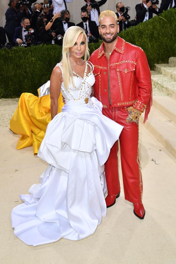 Donatella Versace y Maluma - Alfombra roja de la Gala MET 2021. La diseñadora acudió acompañada del cantante Maluma, que también iba vestido de su firma, y se decantó por un vestido blanco de inspiración 'cowgirl' con tachuelas en el escote y una voluminosa falda satinada.