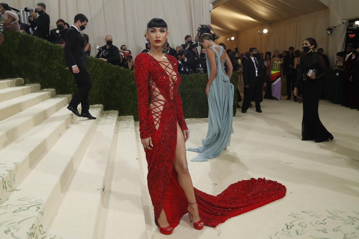 Megan Fox - Alfombra roja de la Gala MET 2021. Hizo del rojo su elección con un diseño de Dundas de lentejuelas rojo con aberturas laterales, una larga cola y abertura lateral que combinó con sandalias con plataforma -de Jimmy Choo-, labios y manicura del mismo color.