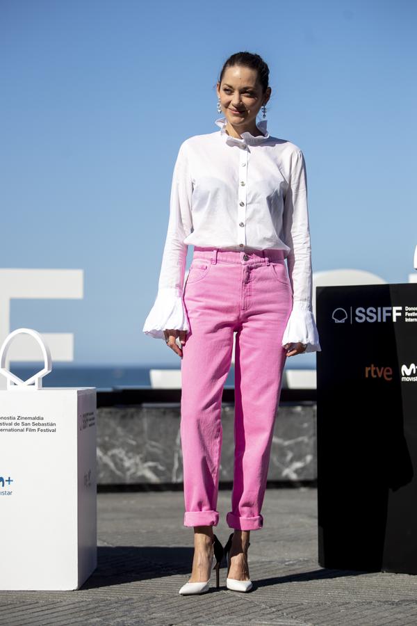 Marion Cotillard durante la rueda de prensa. Uno de sus estilismos más coloridos del festival también viene de la mano de Chanel con unos jeans 'mom fit' fucsia y una blusa blanca con volantes XXL.