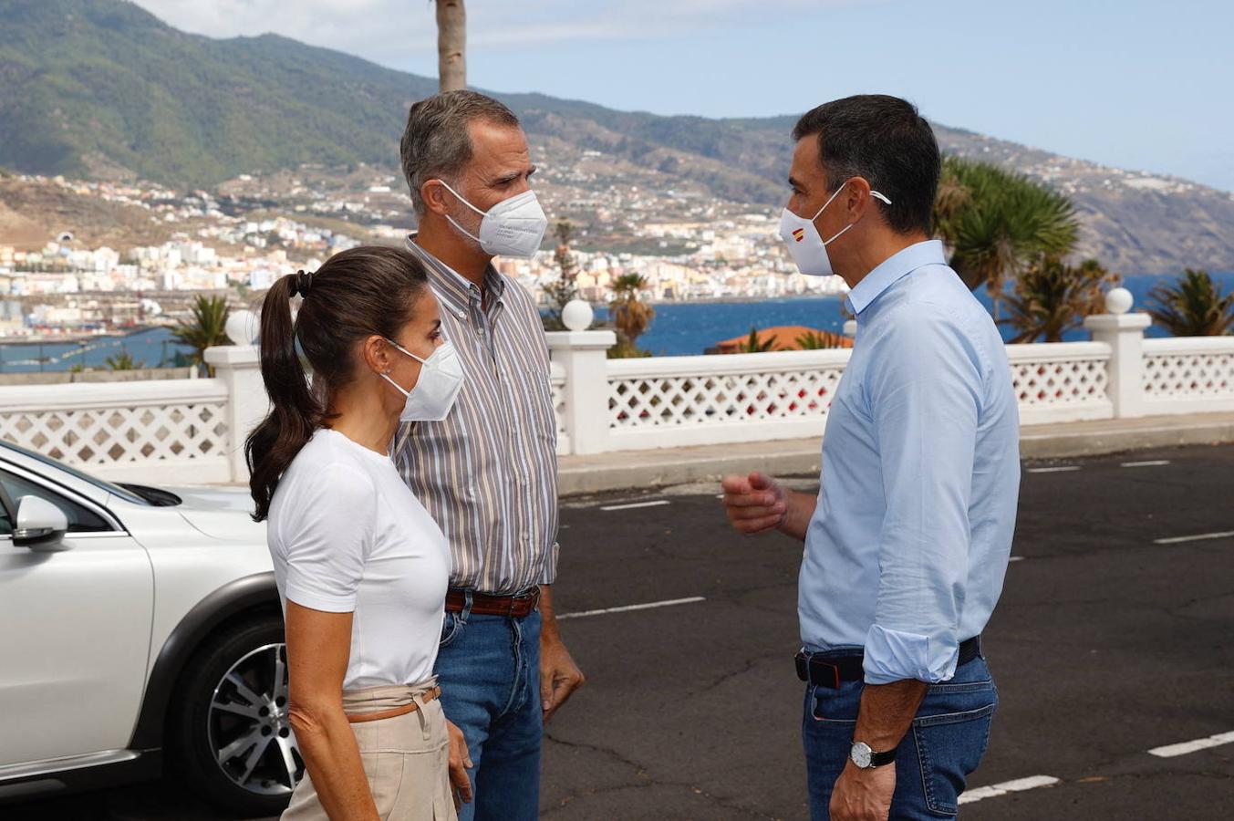 El rey Felipe VI y la reina Letizia hablan con Pedro Sánchez (D) antes de visitar a los afectados por la erupción volcánica en el cuartel de El Fuerte en Breña Baja en la isla canaria de La Palma. 