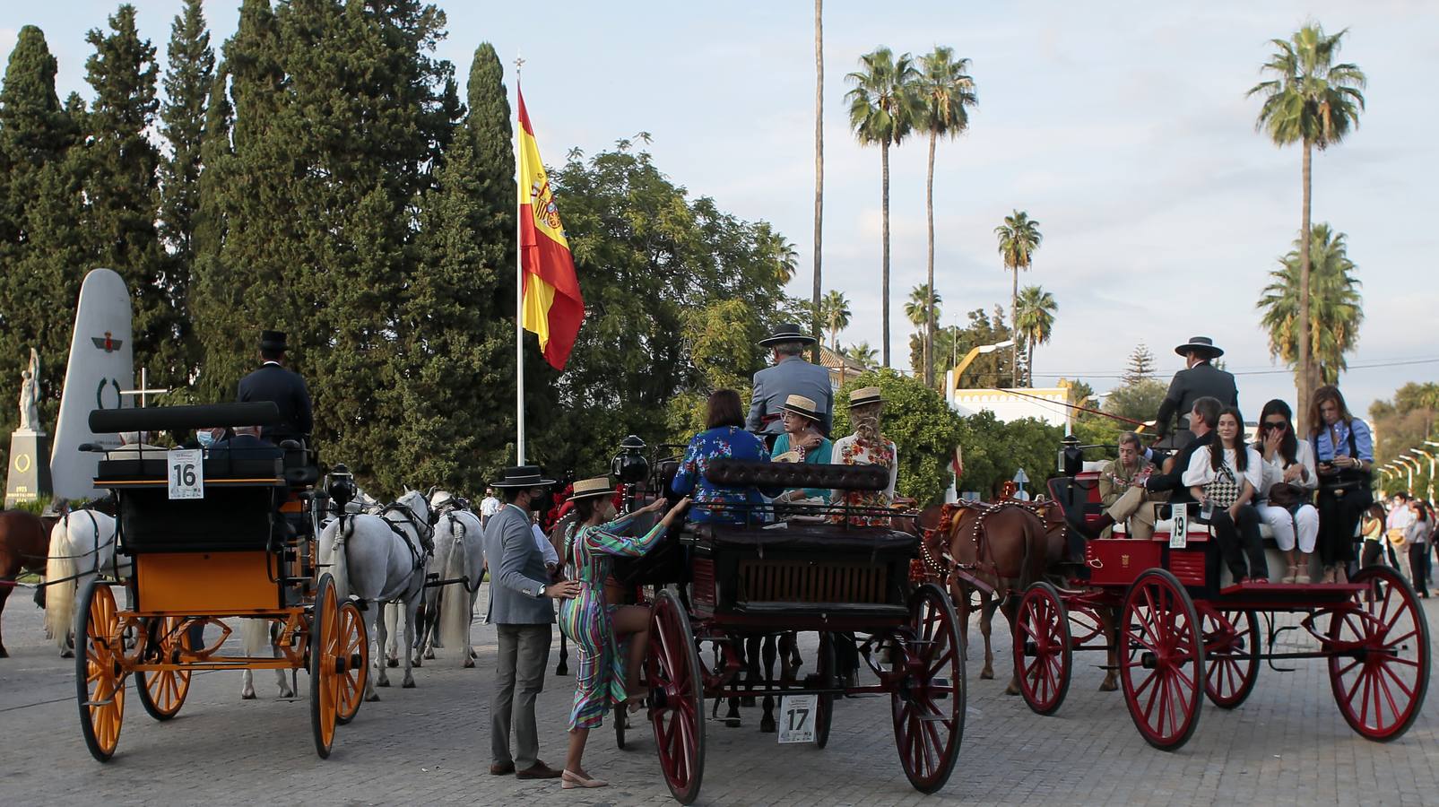 Izado de bandera en Tablada, con los carruajes participantes en el primer paseo por la ciudad.