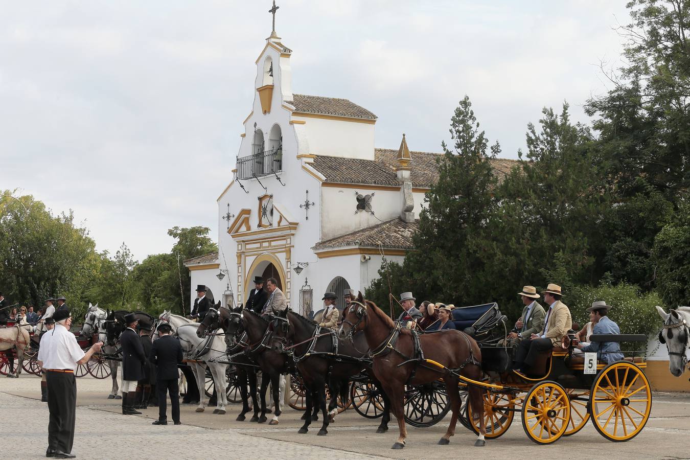 Izado de bandera en Tablada, con los carruajes participantes en el primer paseo por la ciudad.