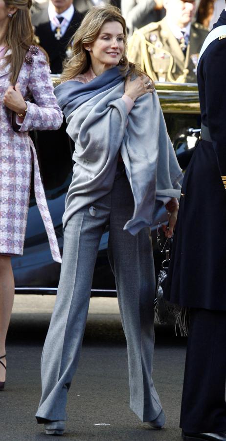 2010 - Los looks de la Reina Letizia en el Día de la Hispanidad. Aquel fue el único año en el que asistió con pantalón y le valió muchas críticas por saltarse el protocolo. Lo hizo con un total look gris de Felipe Varela donde el pantalón se presentaba ligeramente acampanado. Añadió un fular en la parte superior y un bolso de serpiente.