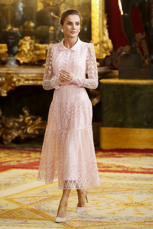 2019 - Los looks de la Reina Letizia en el Día de la Hispanidad. Ese año lució uno de sus conjuntos más primaverales, compuesto por un vestido de tul y seda rosa empolvado de Felipe Varela compuesto por un cuerpo camisero con bordados, transparencias en las mangas y una falda con vuelo. Remató el conjunto con unos mules semitransparentes de Steve Madden y un clutch fucsia de Magrit.