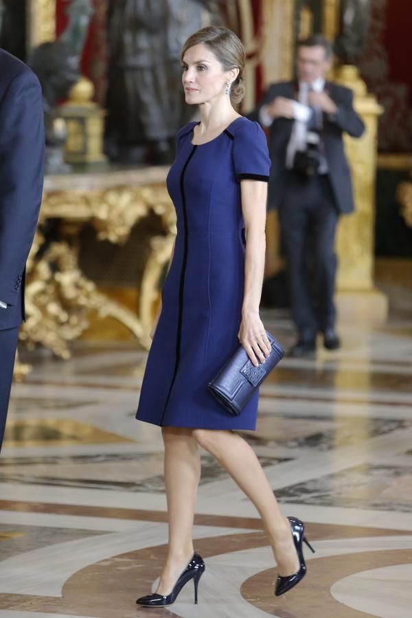 2015 - Los looks de la Reina Letizia en el Día de la Hispanidad. Hizo del azul noche su elección con un vestido midi con el bajo ligeramente acampanado, manga corta y cuello redondo con una línea vertical en el centro de la prenda y los bolsillos. Aunque en la imagen no se ve, poseía una torera a juego. Todo de Felipe Varela.