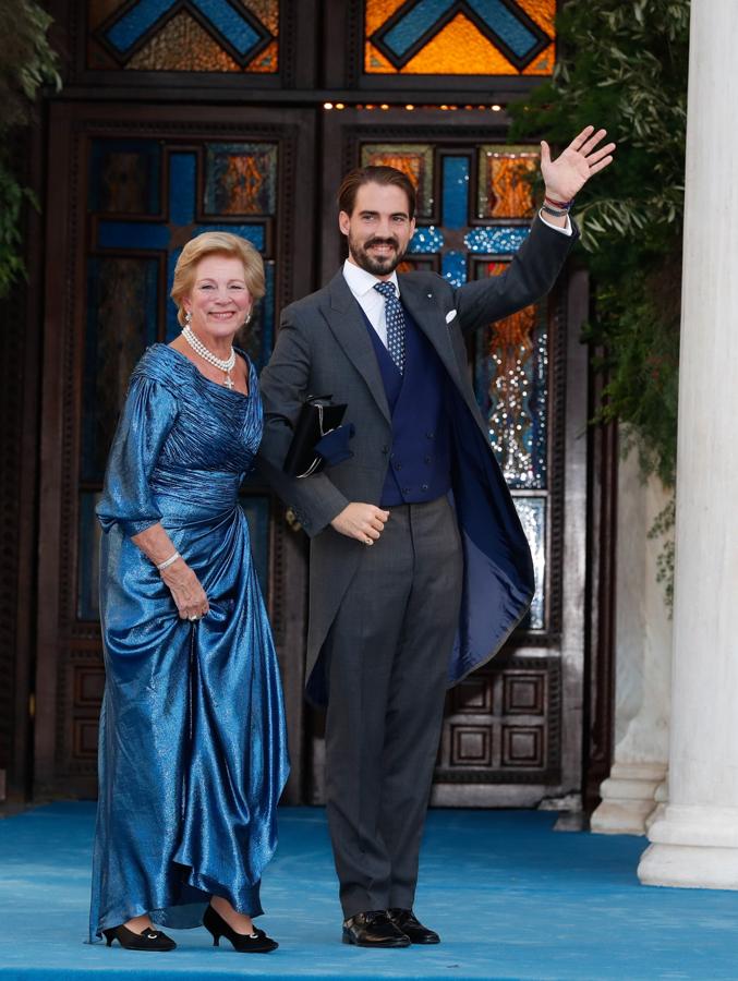 Philippos de Grecia y Dinamarca y su madre Ana María. La madre del novio llevó un vestido azul irisado con drapeados que comenzaban en el escote barco y se complementaban a la perfección con las mangas abullonadas.