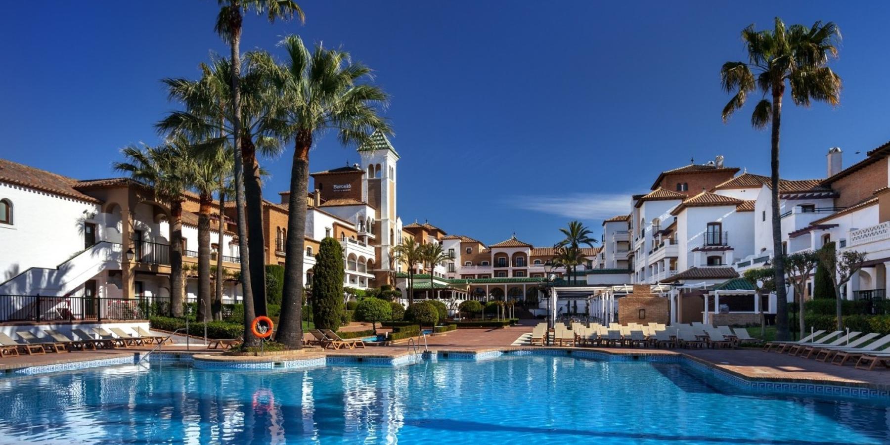 Mejor Resort Todo Incluido de España 2021: Barceló Isla Canela (Huelva). Situado en primera línea de la Costa de la Luz, el Barceló Isla Canela es un hotel diseñado al estilo tradicional de los pueblos andaluces de antaño. Este resort de cuatro estrellas dispone de 349 habitaciones muy luminosas y decoradas con mucho gusto. Entre sus instalaciones destacan un Bar Salón, para tomar cócteles y combinados, un restaurante buffet –considerado de los mejores de España por la variedad de platos y la calidad de sus productos–, un club infantil, para que los más pequeños de la casa puedan disfrutar con diferentes actividades, y una amplia zona ajardinada de influencia árabe.