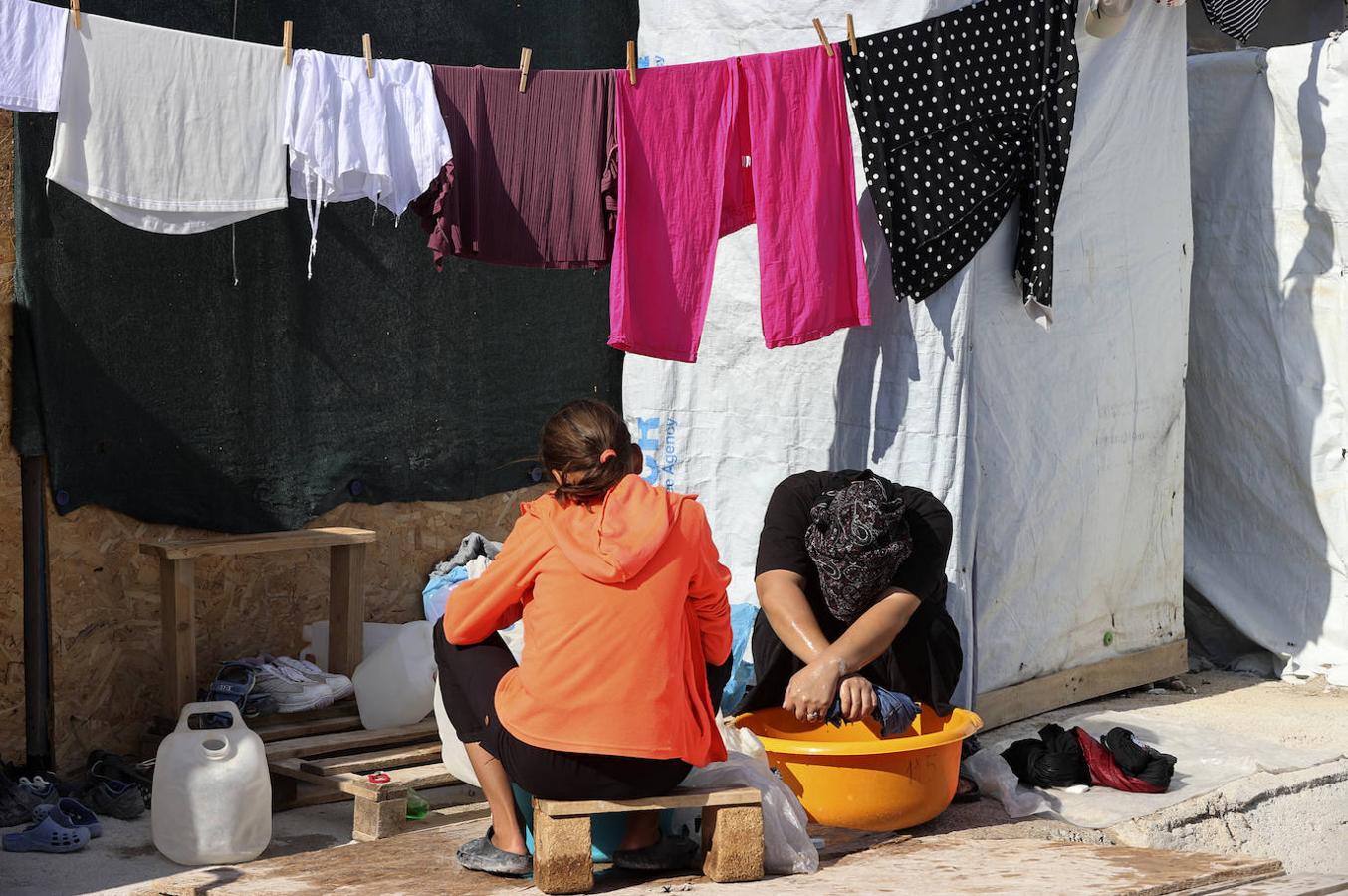 Dos mujeres lavan la ropa en el campo de refugiados. 