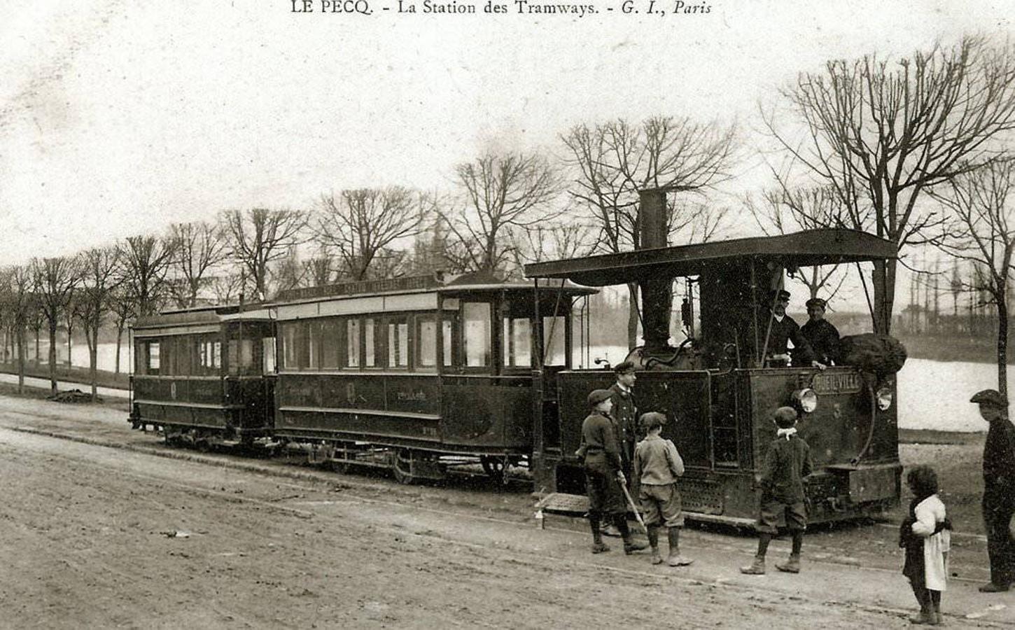 Postal francesa con un tranvía de vapor en la localidad de L´Pecq, cercana a París, hacia 1908. La composición estaba formada por la máquina tractora y dos coches de viajeros. 