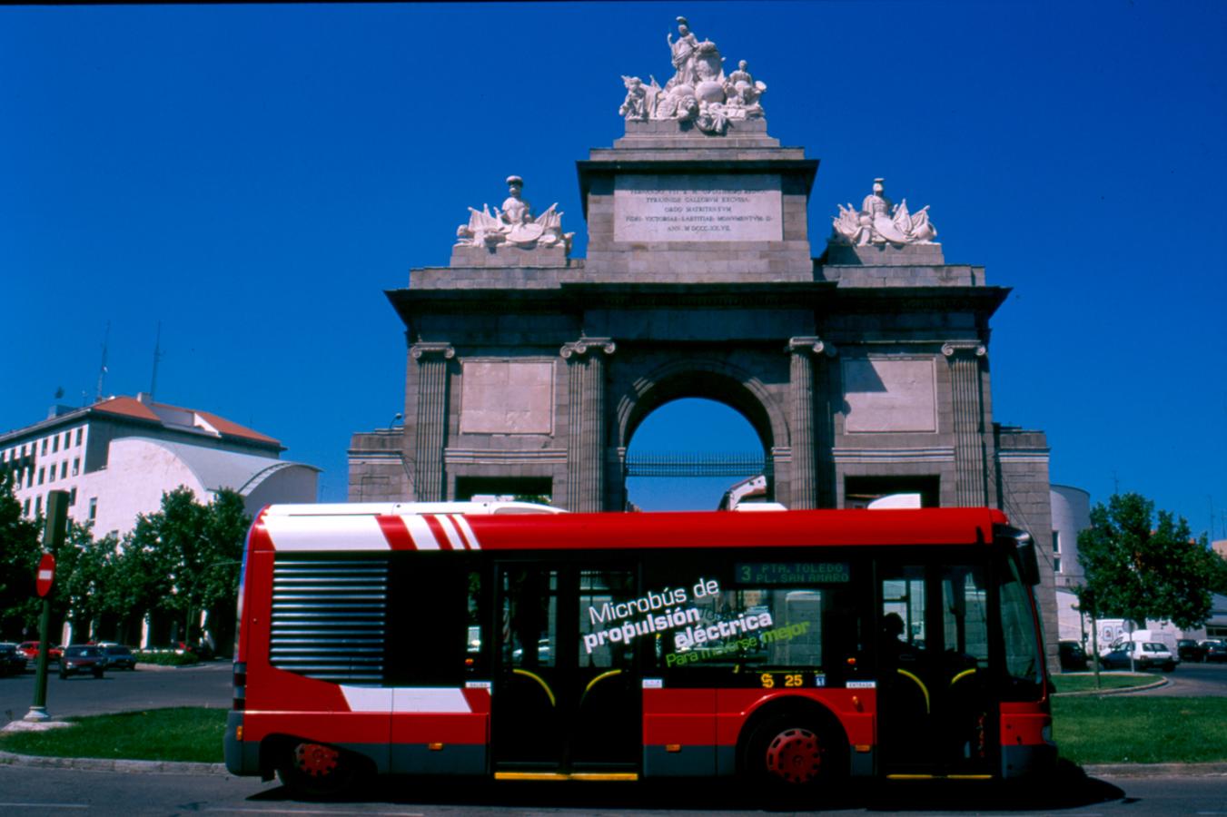 Un microbús de propulsión eléctrica circula frente a la Puerta de Alcalá,. 