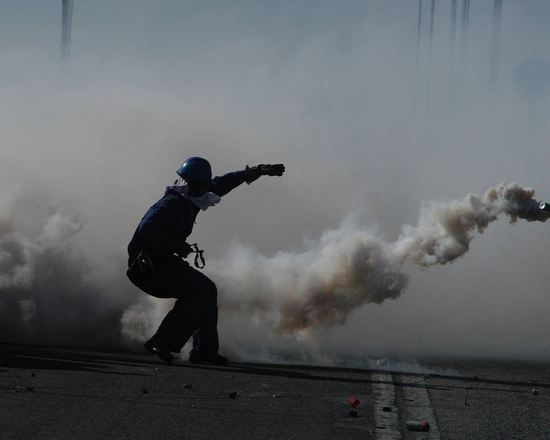 Un manifestante, con su silueta recortada entre una nube de gas lacrimógeno. 