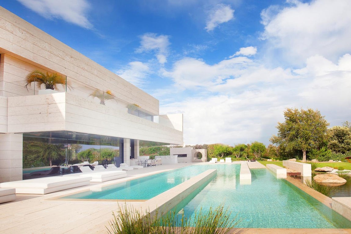 La exclusiva propiedad de La Moraleja para vivir rodeado de lujos. Uno de sus puntos fuertes es el jardín, donde destaca la piscina desbordante dividida en dos partes que se fusiona con una zona de chill out con hamacas para disfrutar al máximo de ella y un espacioso cenador con porche.