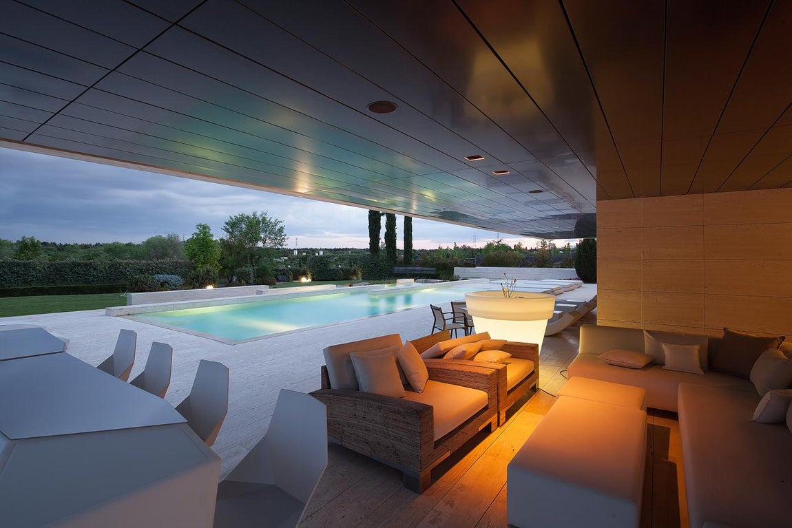 La exclusiva propiedad de La Moraleja para vivir rodeado de lujos. El porche comunica con uno de los salones principales y ofrece una panorámica del jardín donde se pueden disfrutar de las verdes vistas del vecindario. Al encontrarse resguardado y con un techo que cubre la mayor parte de la superficie puede ser utilizado durante todo el año.