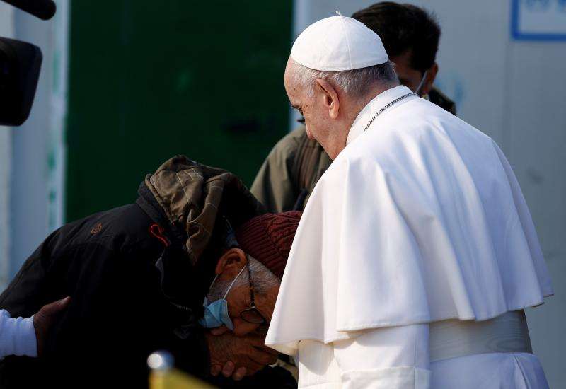 Un refugiado besa emocionado la mano del pontífice. 