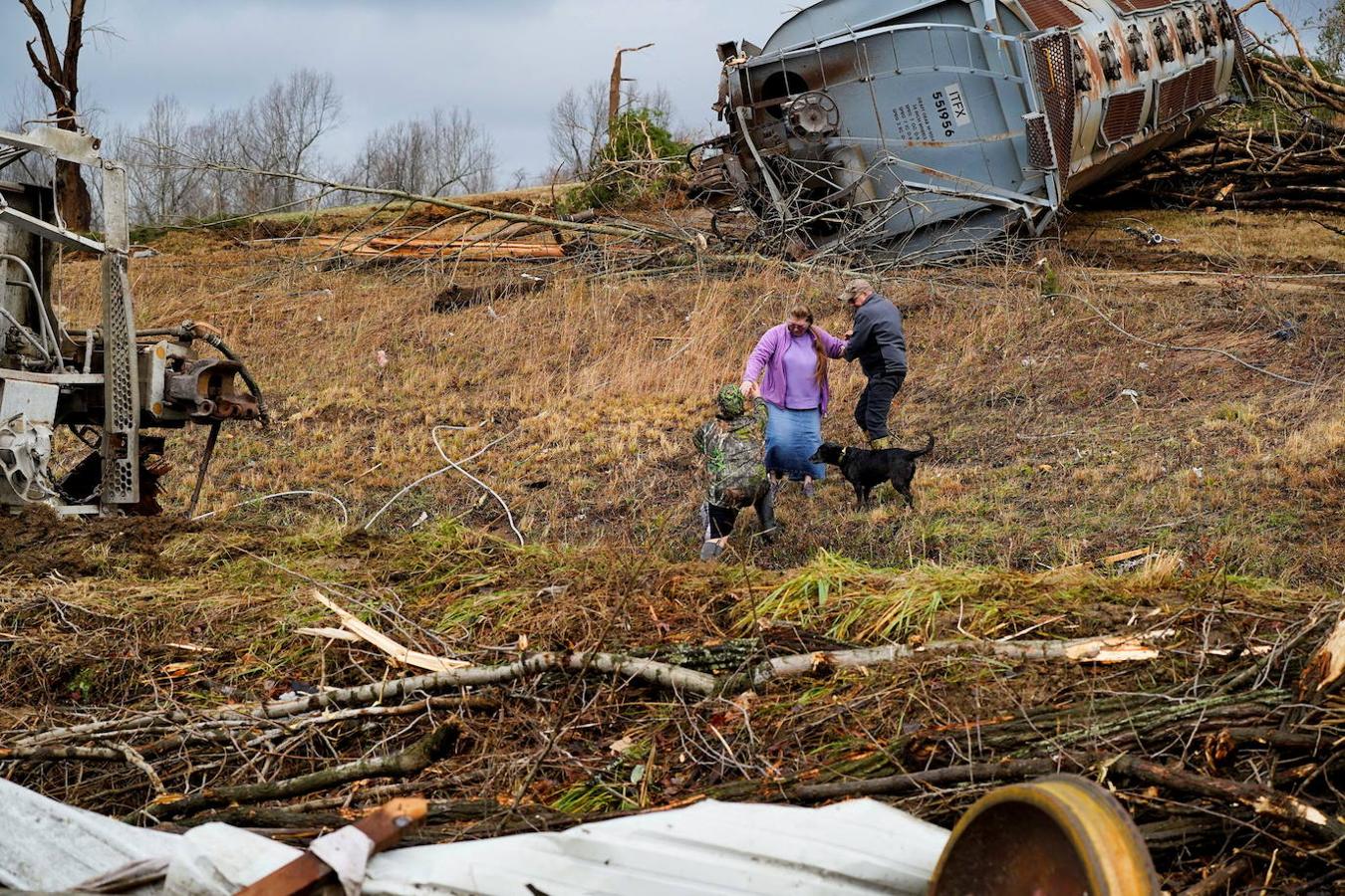 Los residentes locales pasan frente a la escena del descarrilamiento de un tren después de que un devastador brote de tornados arrasara varios estados de EE. UU. En Earlington, Kentucky, EE. UU. El 11 de diciembre de 2021. 