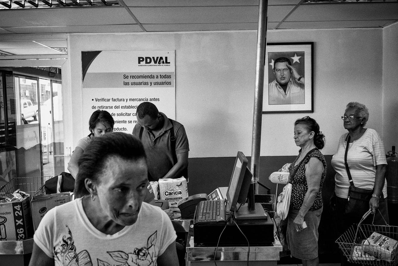 Una mujer hace cola en uno de los numerosos supermercados estatales del régimen bolivariano de Venezuela, los conocidos como proyecto PDVAL. Este proyecto funcionó durante los últimos años del gobierno de Chávez, pero con la llegada de Maduro, el fin de la bonanza petrolera y la destrucción del tejido productivo e industrial del país, se produjo su desaparición. 