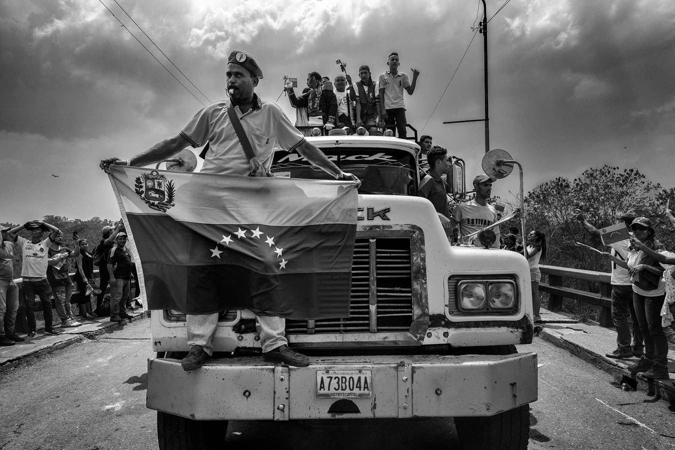 Varios camiones con ayuda humanitaria intentan entrar a Venezuela en febrero de 2019, con manifestantes reunidos en el puente internacional Tienditas. 