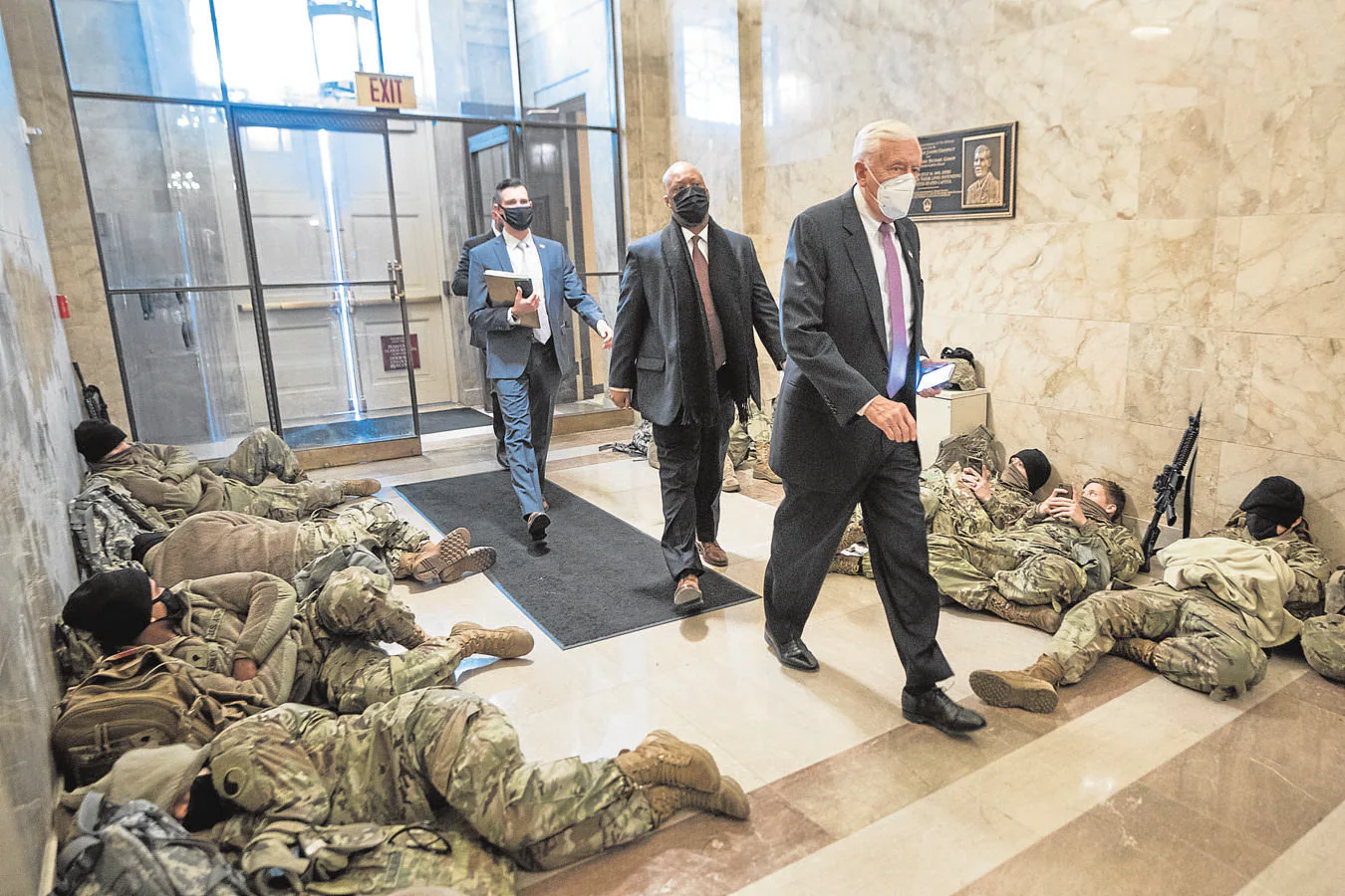 El líder de la mayoría Steny Hoyer pasa junto a miembros de la Guardia Nacional que intentan dormir un poco dentro del Capitolio de los EE. UU.. 