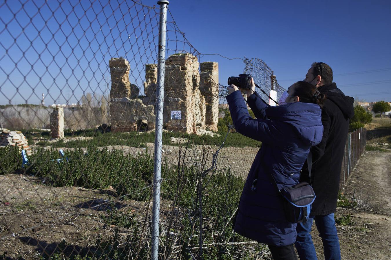 Dos viandantes fotografían desde el exterior de la valla los vestigios de la iglesia, levantada en el S. XVII.. 