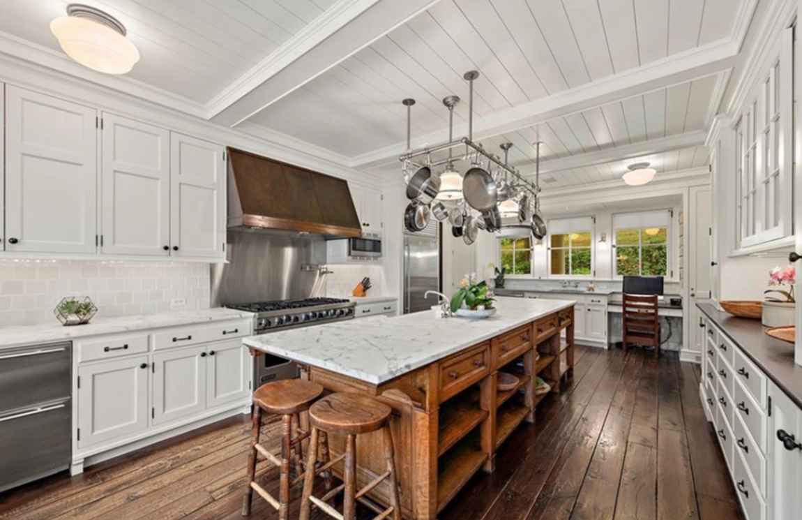 Así es la increíble propiedad que vende Richard Gere. La cocina incluye gabinetes en blanco, encimeras de granito, electrodomésticos en acero inoxidable de alta gama y una isla con espacio extra de almacenaje y barra de desayuno.